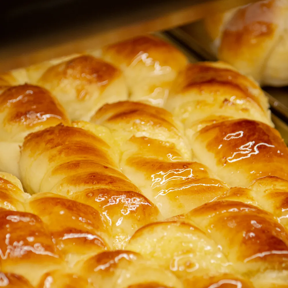 Pães brioche dourados saindo do forno
